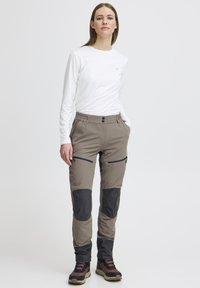 Beige wandelbroeken met zwarte kniestukken en ritszakken. Gemaakt van duurzaam materiaal, met een elastische tailleband en een vlakke voorkant.