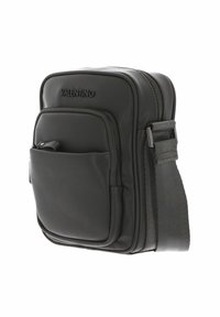 Sac bandoulière en cuir noir à finition texturée, avec un compartiment principal unique, une poche avant, un logo embossé et une bandoulière réglable.