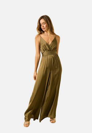 Combinaison vert olive avec un décolleté plongeant, en tissu plissé et jambes larges. Présente des bretelles fines et une taille ceinturée pour une silhouette ajustée.