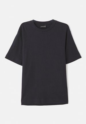 Camiseta de manga corta de canalé en azul marino con cuello redondo, que presenta un logo sutil en la parte inferior derecha. Textura suave, corte relajado.