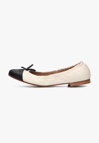 Zwart-witte leren balletschoen met een ronde neus, een decoratieve strik aan de voorkant en een lichtgecushioneerde beige binnenvoering.