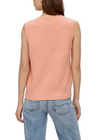 Top senza maniche di maglia rosa pastello con finitura testurizzata e scollatura a coste, indossato con jeans azzurri a vita alta, che mostra la vista posteriore.