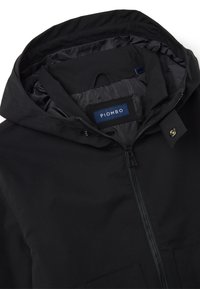 Schwarze wasserdichte Jacke mit Reißverschluss, zwei Fronttaschen und einer verstellbaren Kapuze. Gefüttertes Innenfutter mit einem Etikett, das "PIOMBO" liest.