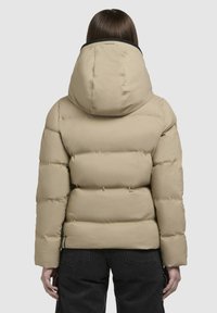 Beżowa kurtka puchowa z dużym kapturem, pikowaną konstrukcją i teksturowaną powierzchnią. Posiada czarny kołnierz i długie rękawy.