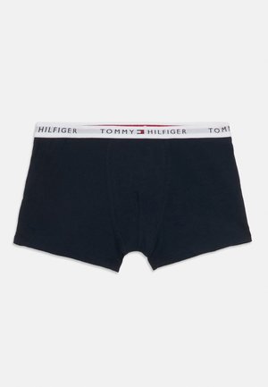 Boxer-briefs bleu marine Tommy Hilfiger avec une ceinture élastique blanche arborant un texte logo noir et un emblème de drapeau rouge, blanc et bleu.