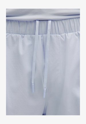 Gaiši zili sporta šorti ar elastīgu jostasvietu un divām gaiši ziliem aukliņām, kas karājas uz priekšu centrā.