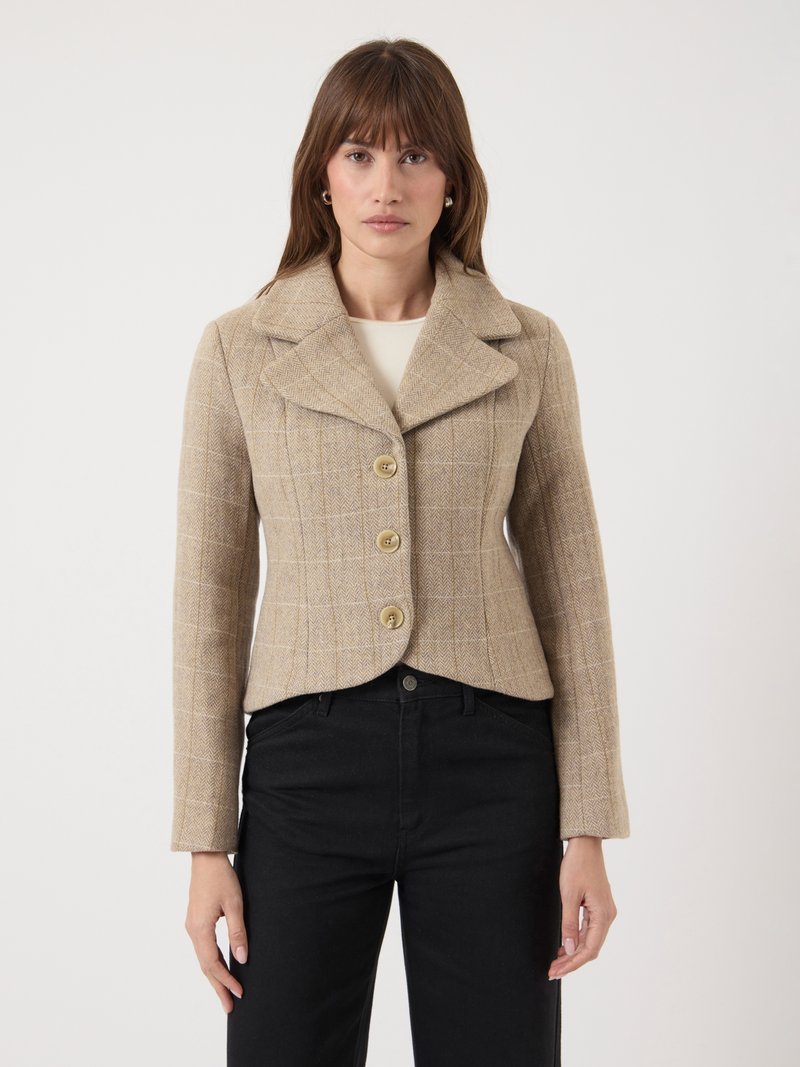 Veste cropped à motif plaid beige avec un large col à crans, trois boutons à l'avant et des manches longues. Portée sur un pantalon noir.