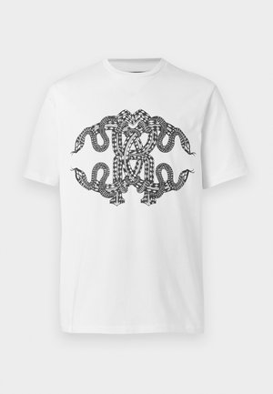 T-shirt blanc avec un motif noir complexe et symétrique de serpents entrelacés sur le devant.
