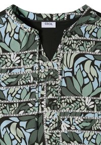 Blouse à motifs verts, bleus et noirs avec des motifs floraux et de chaînes, dotée d'un col rond avec des liens et d'une étiquette blanche "CECIL".