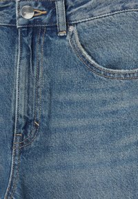 Jeans av denim med en ljusblå tvätt, synlig sömnad, en silverknappsstängning och en framficka. Har en lätt blekning i texturen.