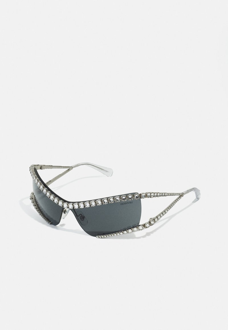 Mustika pruunidega elegantsed prillid mustas raamistikus, tumedate läätsedega ja hõbedaste aksessuaaridega. Ülalt ja külgedelt kulgeb rida selgeid kristalle.