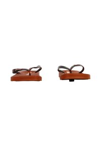 Brune gummiklippere med flade såler, der har krydsseler og subtile logodetaljer på den øverste sikkerhedsanordning. Glat, mat finish.