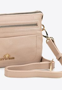 Světle béžová kožená crossbody kabelka s texturovaným povrchem, vybavená zipovou kapsou a odnímatelným popruhem. Obsahuje zlaté akcenty.