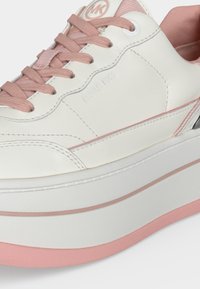 Λευκό sneaker με πλατφόρμα, ροζ κορδόνια, ροζ εσωτερικό, στρογγυλεμένη μύτη και διακριτικό ανάγλυφο λογότυπο "Michael Kors" στο πλάι.