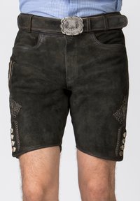 Pantaloni corti neri in suede con ricami decorativi in argento sui lati e bottoni bianchi lungo l'orlo. Abbinati a una cintura in pelle scura.