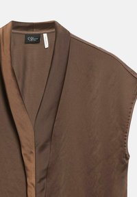 Brown sleeveless blouse with a deep V-neck and soft satin trim on shoulders and neckline, fabric tag visible inside collar.
