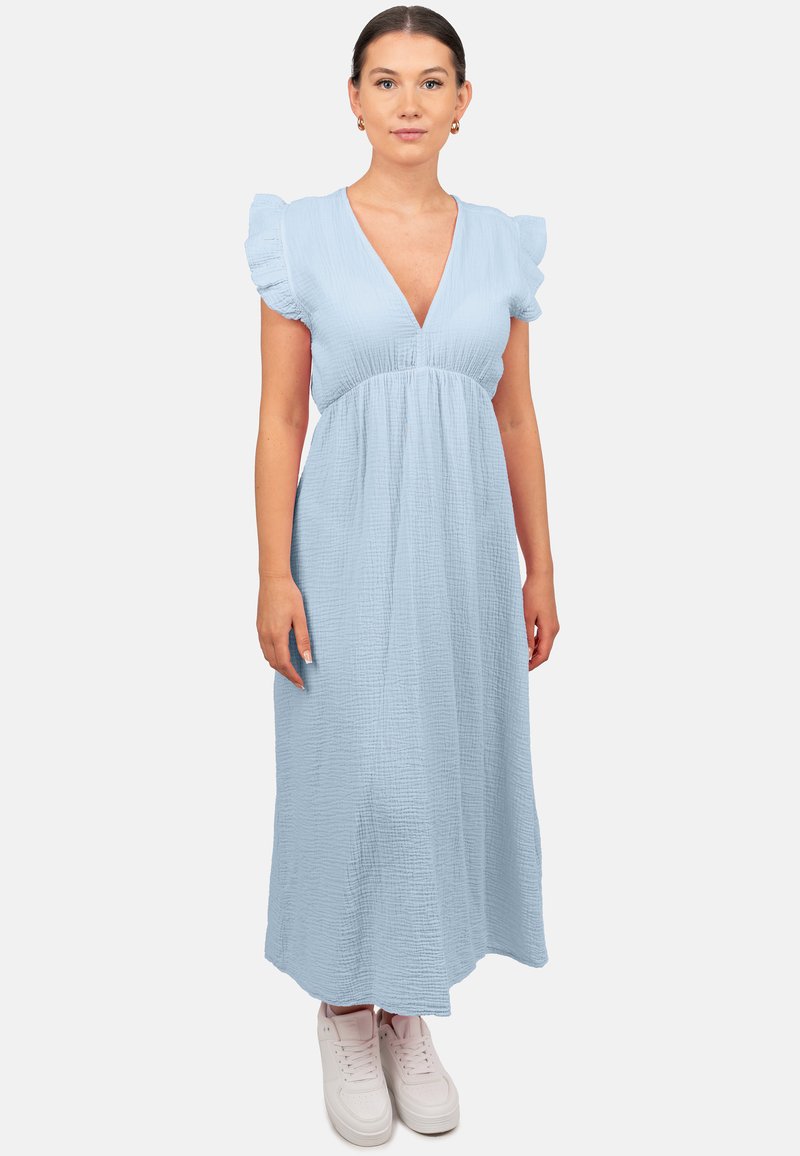 Lichtblauwe, vloeiende maxi-jurk met een V-halslijn en gerimpelde korte mouwen; textuurstof; gecombineerd met witte sneakers.