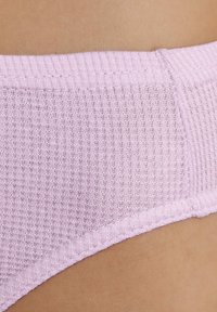 Sous-vêtements en tissu côtelé rose avec une ceinture élastique lisse, présentant un motif texturé et des bords sans couture pour le confort.