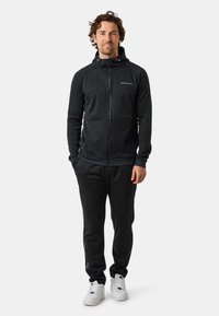 Donkergrijze heren hoodie met rits en een minimalistisch ontwerp, gecombineerd met bijpassende sweatpants. De hoodie heeft twee voorkleppen en een verstelbare capuchon.