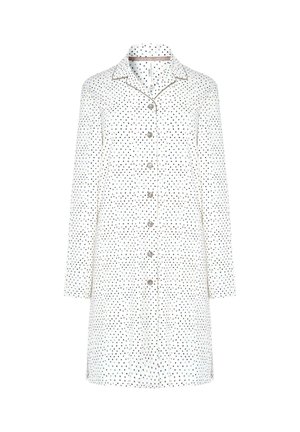 Camisa blanca de vestir con botones, con un estampado de lunares en colores negro y metálicos, de mangas largas y con un ribete de cuello en contraste.