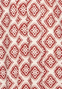 Tessuto a motivi rosso e bianco con un design a diamante ripetuto, arricchito da elementi floreali e accenti arrotondati, realizzato in un tessuto leggero.