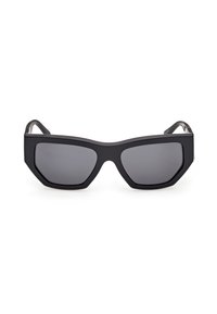 Lunettes de soleil rectangulaires surdimensionnées noires avec des montures épaisses et des verres teintés foncés, présentées sur un fond blanc.
