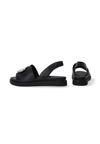 Schwarze Leder-Slingback-Sandalen mit einer runden Zehenpartie, flacher Sohle und einem glänzenden metallischen Akzent an der Vorderseite. Sie haben eine glatte Oberfläche.