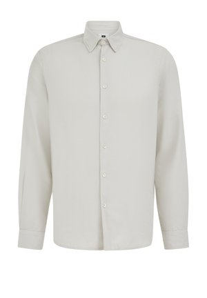 Dolga bež srajca z dolgimi rokavi, ovratnikom z ostrimi konicami in zapenjanjem na gumbe na manšetah, prikazana na belem ozadju.