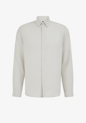 Šviesiai smėlio spalvos ilgomis rankovėmis marškiniai su sagomis, smailiu apykakliu ir segamais rankogaliais, rodomi ant paprastos baltos fono.