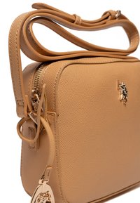 Borsa a tracolla di media grandezza in pelle color tan con finitura testurizzata, dotata di chiusura con zip e dettagli in metallo color oro.