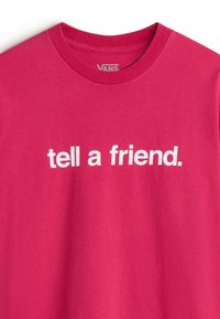 Rosa bomulds T-shirt med fed hvid tekst, der står "fortæl en ven." Korte ærmer og rund halsudskæring. Glat tekstur.