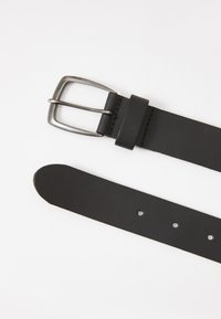 Ceinture en cuir noir avec une boucle en métal argenté, présentant une texture lisse, des trous pour l'ajustement et une extrémité arrondie.
