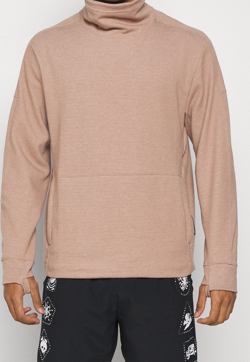 Sudadera de cuello alto en color rosa claro, fabricada en un tejido suave y con mangas largas. Presenta un bolsillo frontal con costura y detalles acanalados en el cuello y los puños.