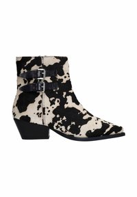 Bottes ankle en cuir de vache avec un motif tacheté noir et blanc, dotées de deux sangles noires et de boucles argentées, à bout effilé et à talon bas.