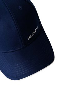 Navyblauwe stoffen pet met een gebogen klep, voorzien van witte stiksels en het "HACKETT"-logo in zilver aan de zijkant.