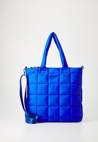 Sac fourre-tout bleu rembourré, de forme rectangulaire, avec une texture matelassée, des poignées doubles et une sangle amovible. Présente une fermeture zippée et un détail de logo.