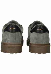 Pilkos zomšinės bateliai su apvaliu dizainu, juodais odiniais kulno akcentais ir rudos gumos padu. Auksinė ženklinimo detalė ant kulno ir pado.