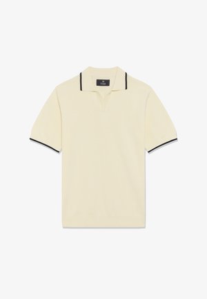 Kreemjas lühikeste varrukatega polo-särk musta äärisega krae ja varruka servadel, millel on väike lõhike krae all.