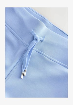 Světlomodrá látka s hladkou texturou, s detailem stahovací šňůrky se stříbrnými koncovkami a plochými švy. Jemný a jednotný design.