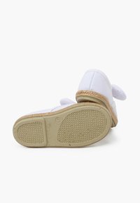 Baltas kanvas espadrillis ar pītas jutas vidusējo zoli, teksturētu gumijas zoli un apaļas formas purngalu. Gluda virsma ar dekoratīviem akcentiem uz papēža.