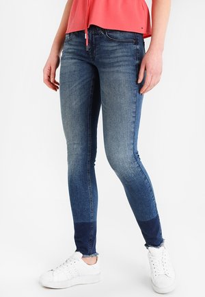 Skinny jeans in donkerblauw denim met een vervaagde was, voorzien van een contrasterende donkerdere blauwe paneel bij de enkels en een rafelige zoom.