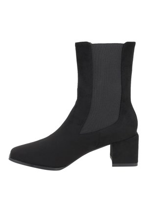 Stivale alla caviglia nero con tacco a blocco, caratterizzato da una finitura in suede liscia e pannelli laterali in tessuto elasticizzato per una facile calzata. Design con punta affilata.