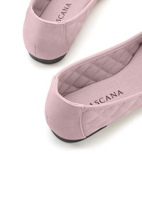 Rosafarbene Ballettschuhe aus weichem Wildleder, mit einem gesteppten Design an der Ferse und einer flexiblen schwarzen Gummisohle. Innen ist sie mit einem strukturierten Futter ausgestattet.