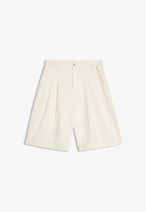 Pantaloncini color crema su misura con pieghe, tasche laterali, passanti per cintura e chiusura frontale con bottoni.