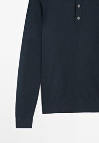 Polo en maille bleu marine foncé à manches longues avec patte de boutonnage à trois boutons et poignets côtelés, présenté de la poitrine à l'ourlet sur fond blanc.