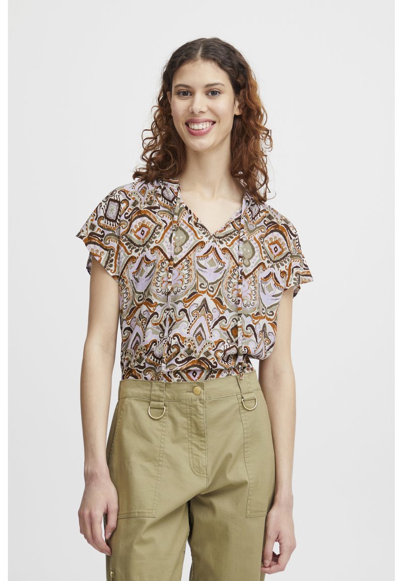Blouse à motifs multicolores avec un décolleté en V et des manches courtes, en tissu léger, assortie à un pantalon khaki taille haute.