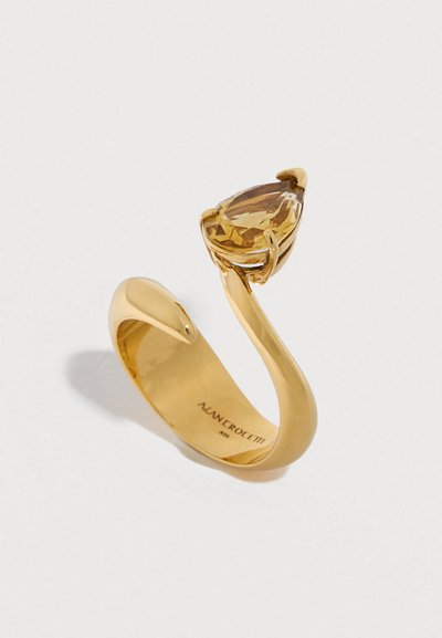 Χρυσό δαχτυλίδι με κίτρινο πολύτιμο λίθο σε σχήμα αχλαδιού, ανοιχτό σχέδιο φιδιού με λείο φινίρισμα και χαραγμένο όνομα επωνυμίας στο εσωτερικό της μπάντας.