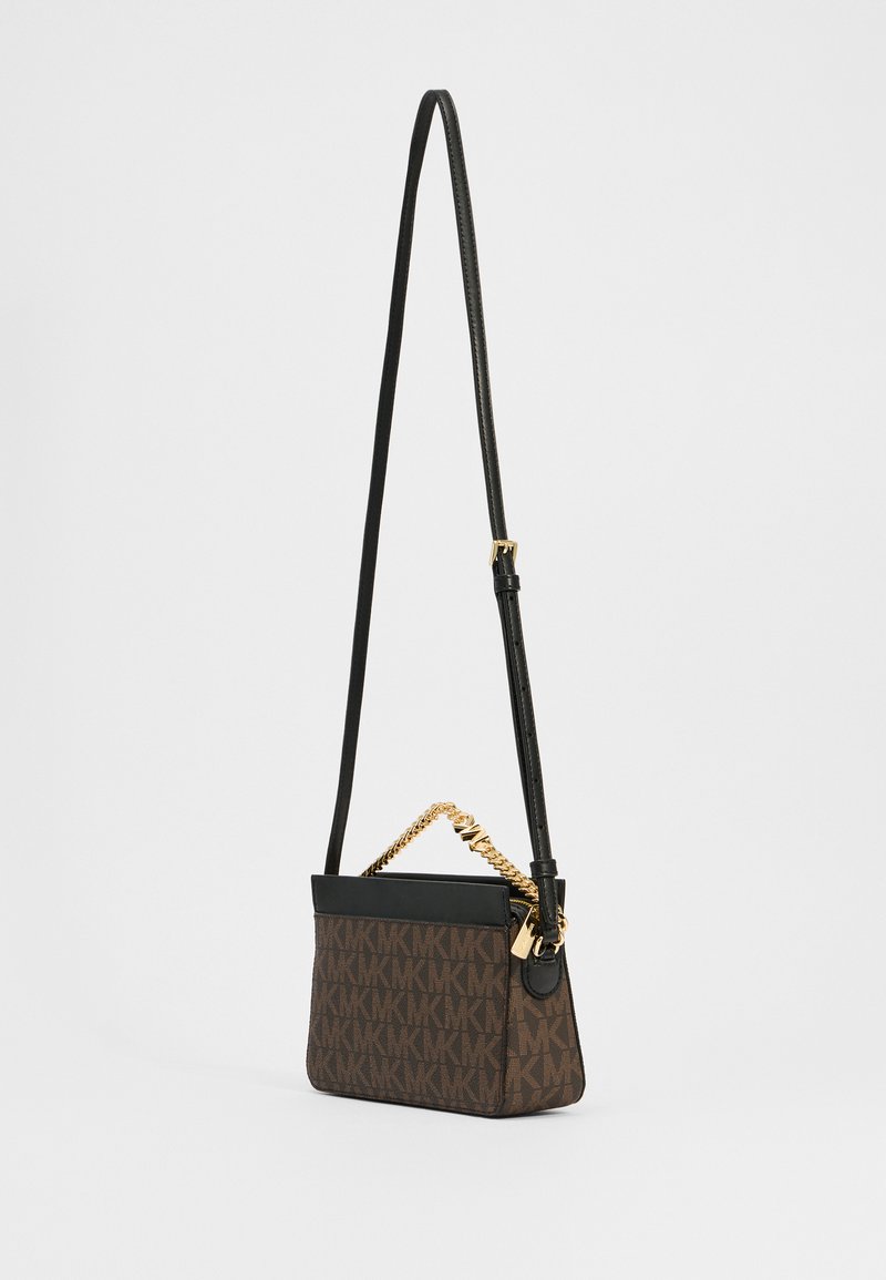 Bruine handtas met logo-patroon, voorzien van een zwarte leren bovenkant, gouden kettingaccent en een verstelbare schouderband, met een slanke rechthoekige vorm.