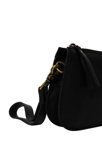 Borsa a mano in pelle nera con forma curvata, dotata di chiusura a scatto in tonalità oro, chiusura con zip e un manico corto. Dettagli della superficie testurizzata visibili.