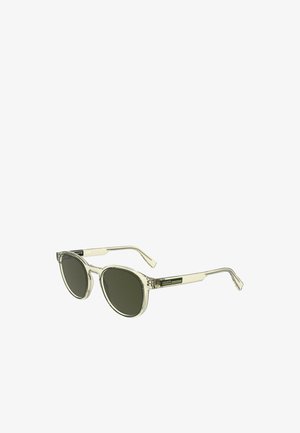 Occhiali da sole con montatura trasparente e lenti verde scuro, forma rotonda e design elegante. Presenta un logo sulla stanghetta con un accento a righe.